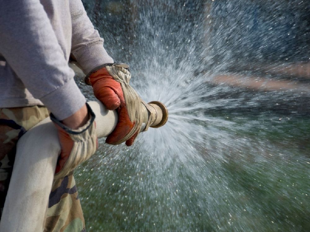a person learning how to use a fire hose reel